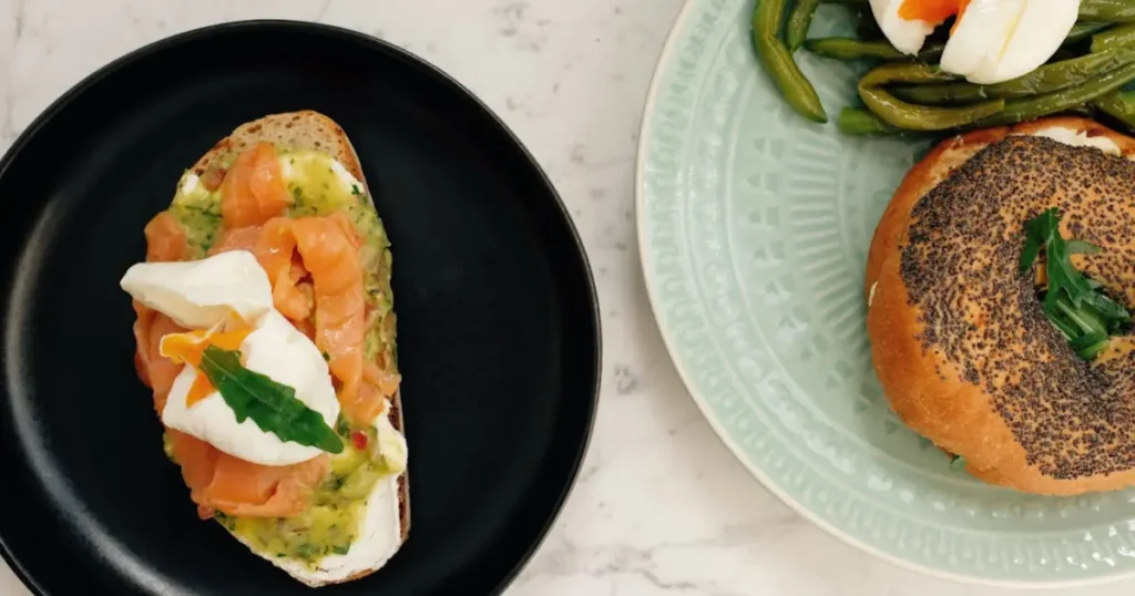 Avocado Toast with Poached Egg & Smoked Salmon topped with fresh herbs on a crisp slice of bread, a healthy and delicious breakfast option