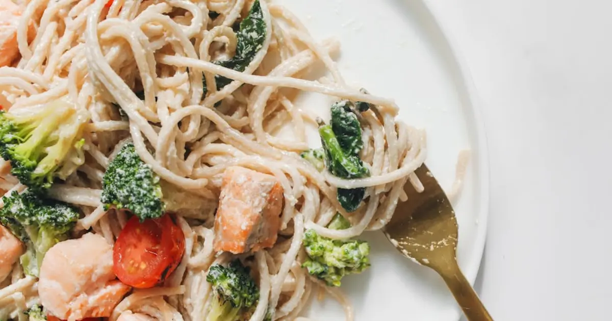 A bowl of creamy smoked salmon pasta with broccoli, featuring tender pasta coated in a rich, velvety sauce, with vibrant green broccoli florets and delicate flakes of smoked salmon throughout