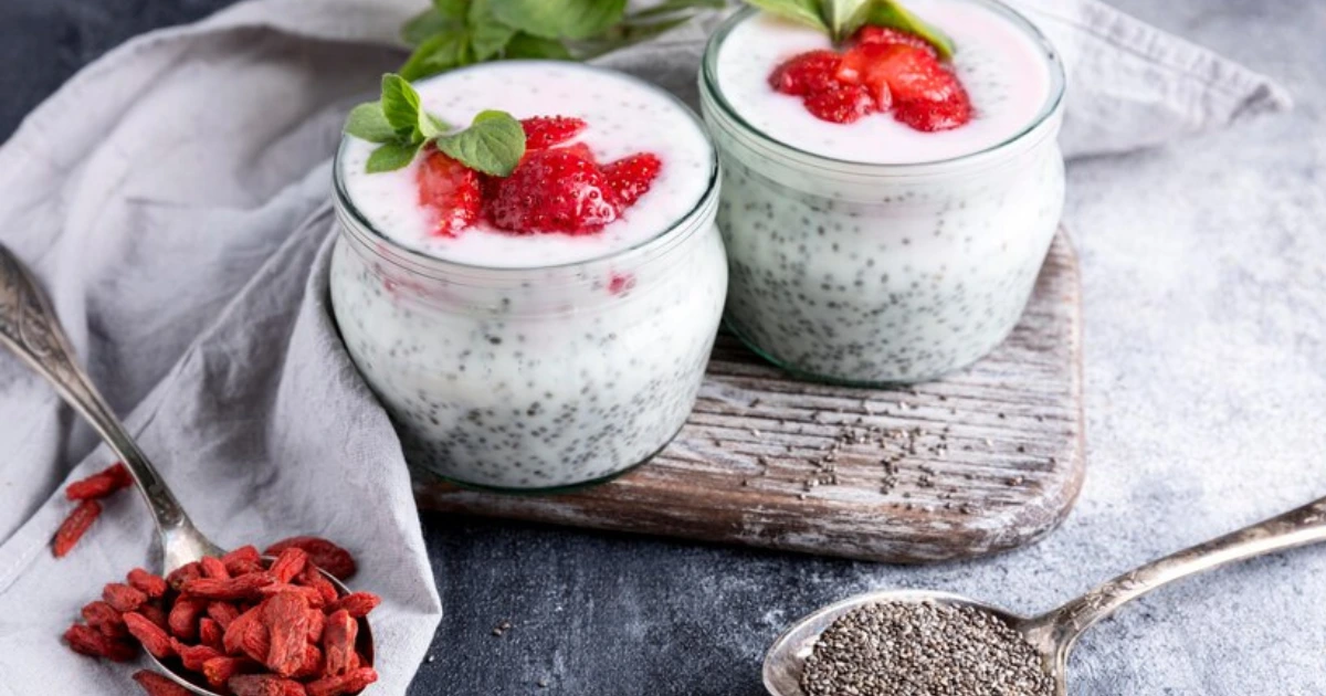 Chia seed pudding made with almond milk, garnished with sliced strawberries and a drizzle of almond butter.