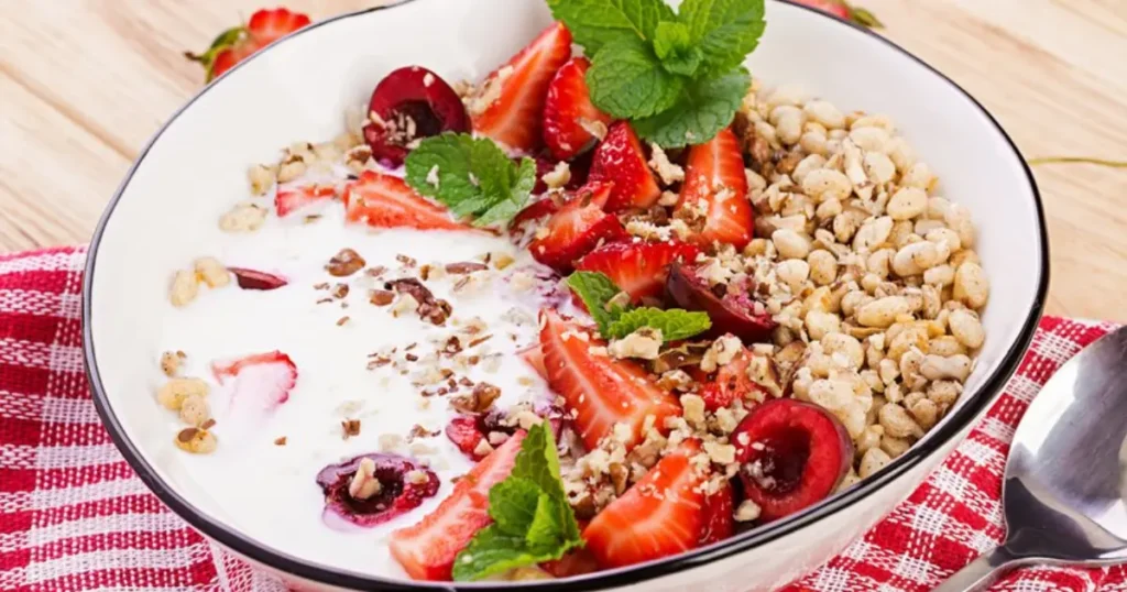 A bowl of creamy Greek yogurt topped with fresh berries and a drizzle of honey