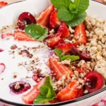 A bowl of creamy Greek yogurt topped with fresh berries and a drizzle of honey