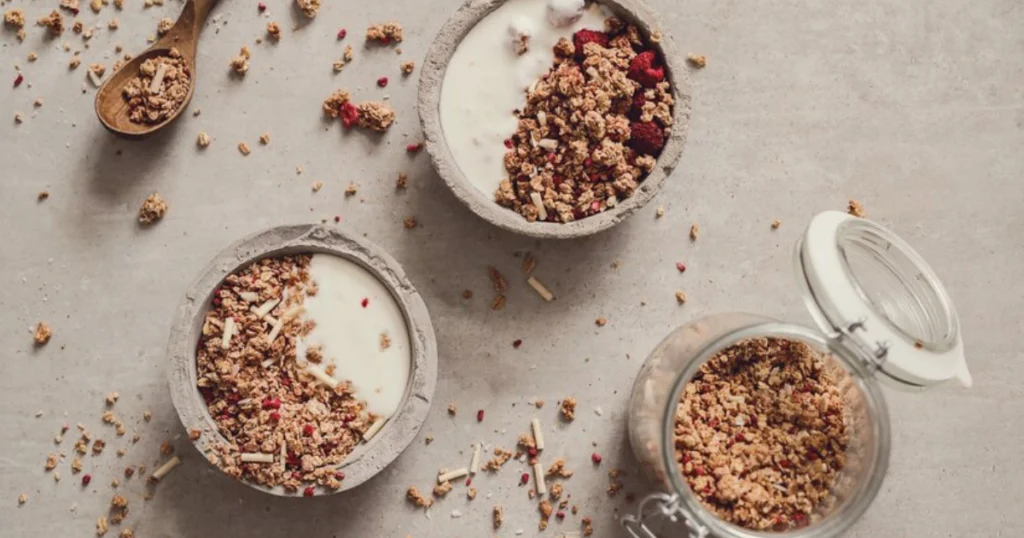 Granola and yogurt bowl with crunchy toppings and a drizzle of maple syrup