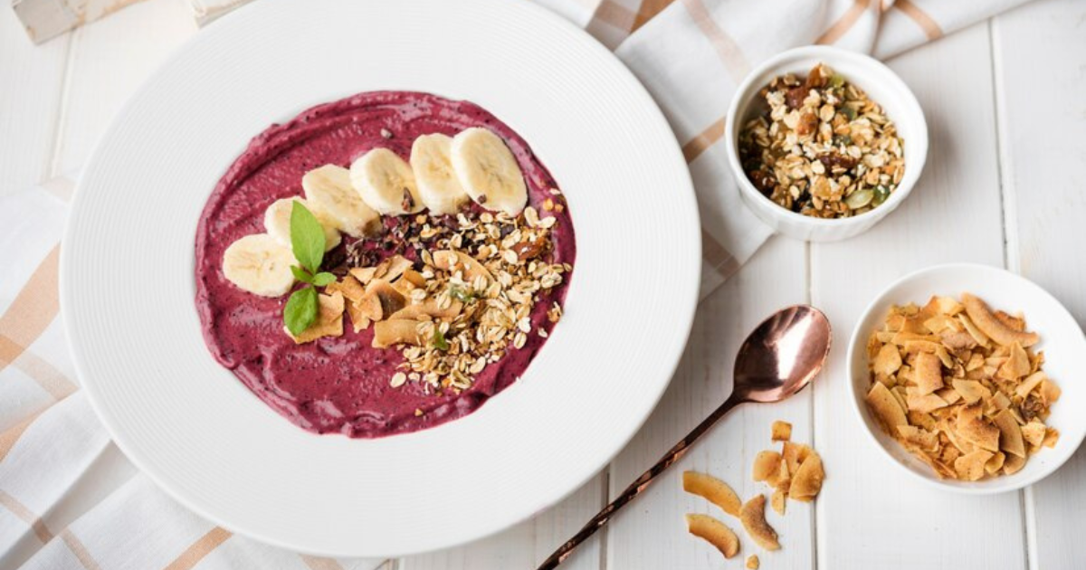 Smoothie Bowl with Banana and Almond Butter topped with fresh blueberries, granola, and banana slices.